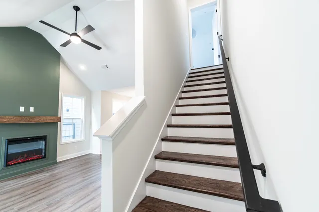 an empty room with windows and ceiling fan