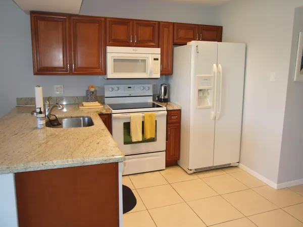 a kitchen with stainless steel appliances granite countertop a refrigerator stove and sink