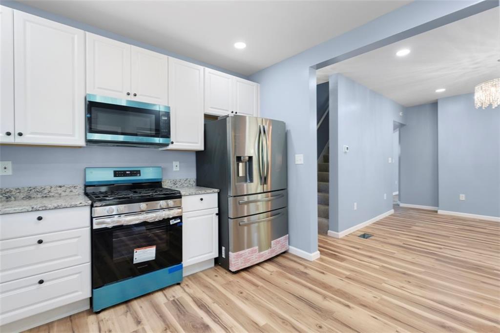 1105 Stock Street Pittsburgh, PA 15207 - Photo 12 of 37 a kitchen with granite countertop wooden floor stainless steel appliances and wooden cabinets