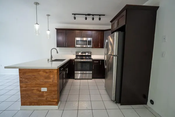 a kitchen with stainless steel appliances granite countertop a refrigerator and a sink