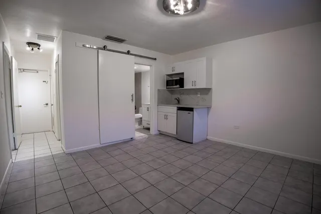a view of kitchen with refrigerator cabinets and microwave