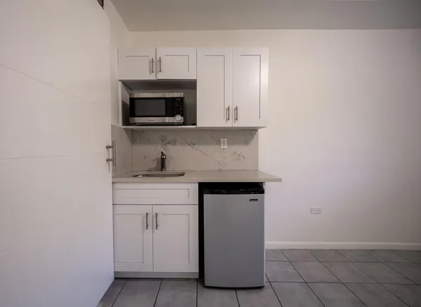 a kitchen with granite countertop white cabinets and white appliances