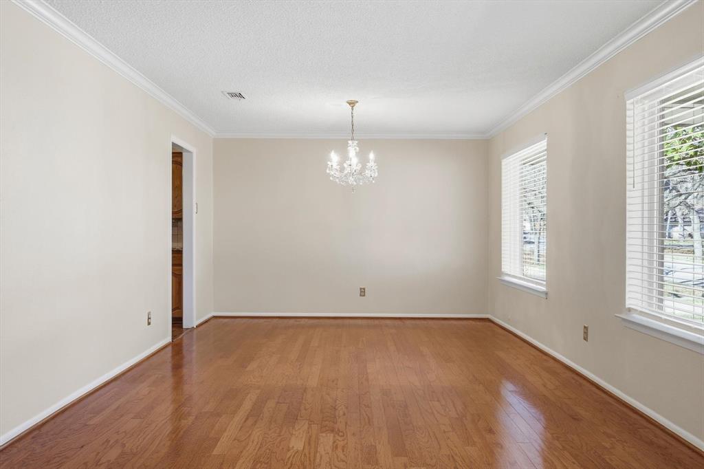 503 Summit Ridge Drive Euless, TX 76039 - Photo 7 of 38 an empty room with wooden floor chandelier and windows