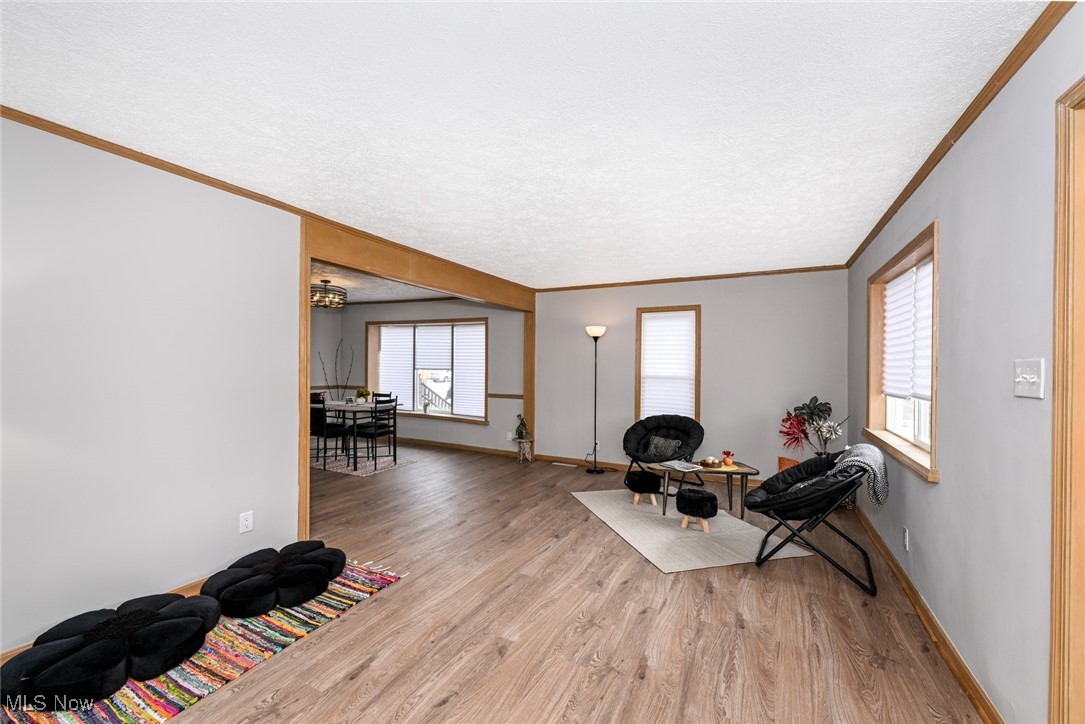 1164 Copley Road Akron, OH 44320 - Photo 19 of 50 Sitting room with light wood finished floors, a textured ceiling, baseboards, and crown molding