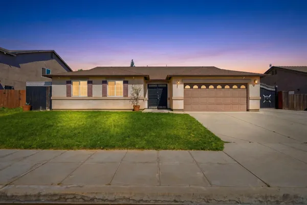 a front view of a house with a garden and yard