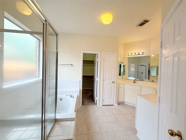 a bathroom with a tub shower and sink