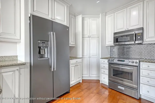 a kitchen with stainless steel appliances granite countertop a refrigerator and a stove top oven