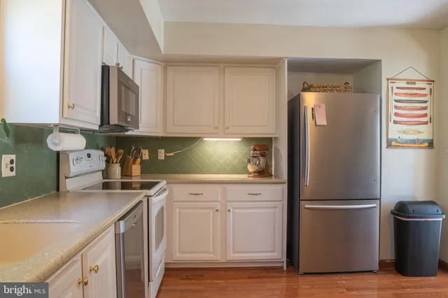 a kitchen with a refrigerator sink and cabinets