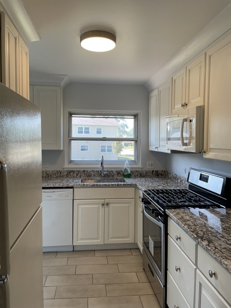449 Yarmouth Road Elk Grove Village, IL 60007 - Photo 6 of 48 a kitchen with granite countertop a sink stainless steel appliances and cabinets