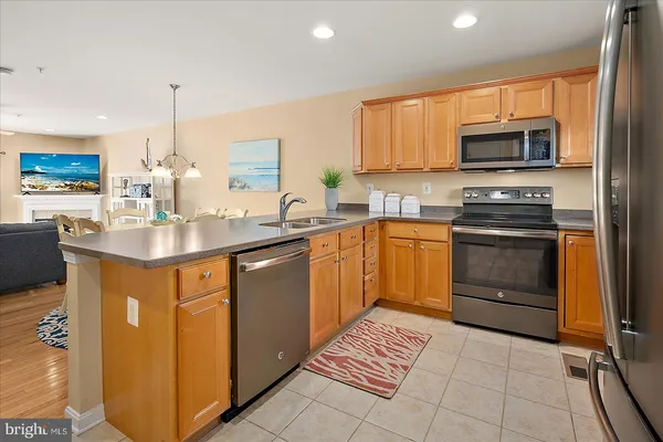 a kitchen with stainless steel appliances granite countertop a stove top oven a sink a counter top space and cabinets