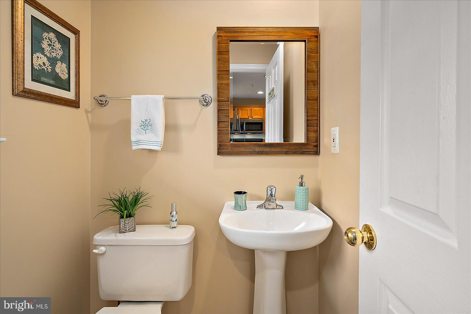 617 Salt Spray Road, Unit D Ocean City, MD 21842 - Photo 18 of 69 a bathroom with a toilet sink and mirror
