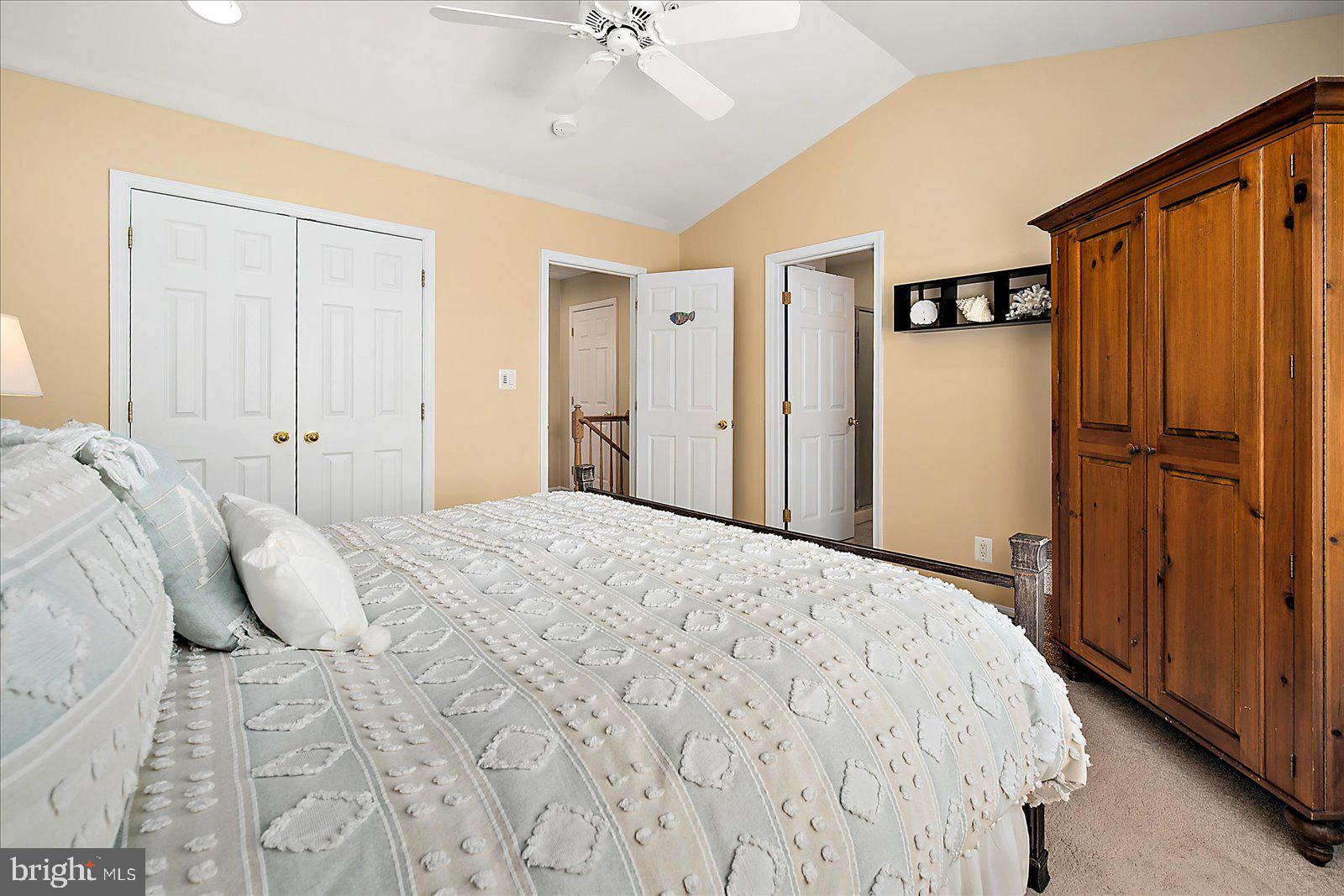 617 Salt Spray Road, Unit D Ocean City, MD 21842 - Photo 22 of 69 a bedroom with a large bed a chandelier and closet