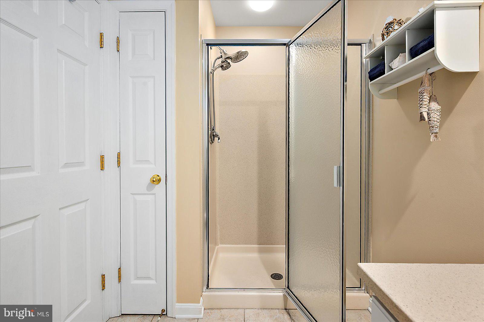617 Salt Spray Road, Unit D Ocean City, MD 21842 - Photo 23 of 69 a bathroom with a shower and a glass door