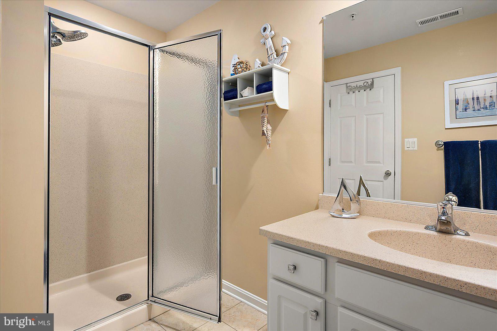 617 Salt Spray Road, Unit D Ocean City, MD 21842 - Photo 24 of 69 a bathroom with a shower sink and mirror