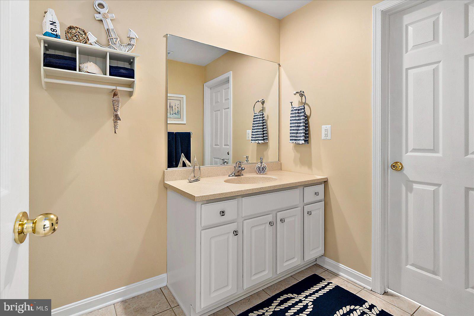 617 Salt Spray Road, Unit D Ocean City, MD 21842 - Photo 25 of 69 a bathroom with a sink and a mirror