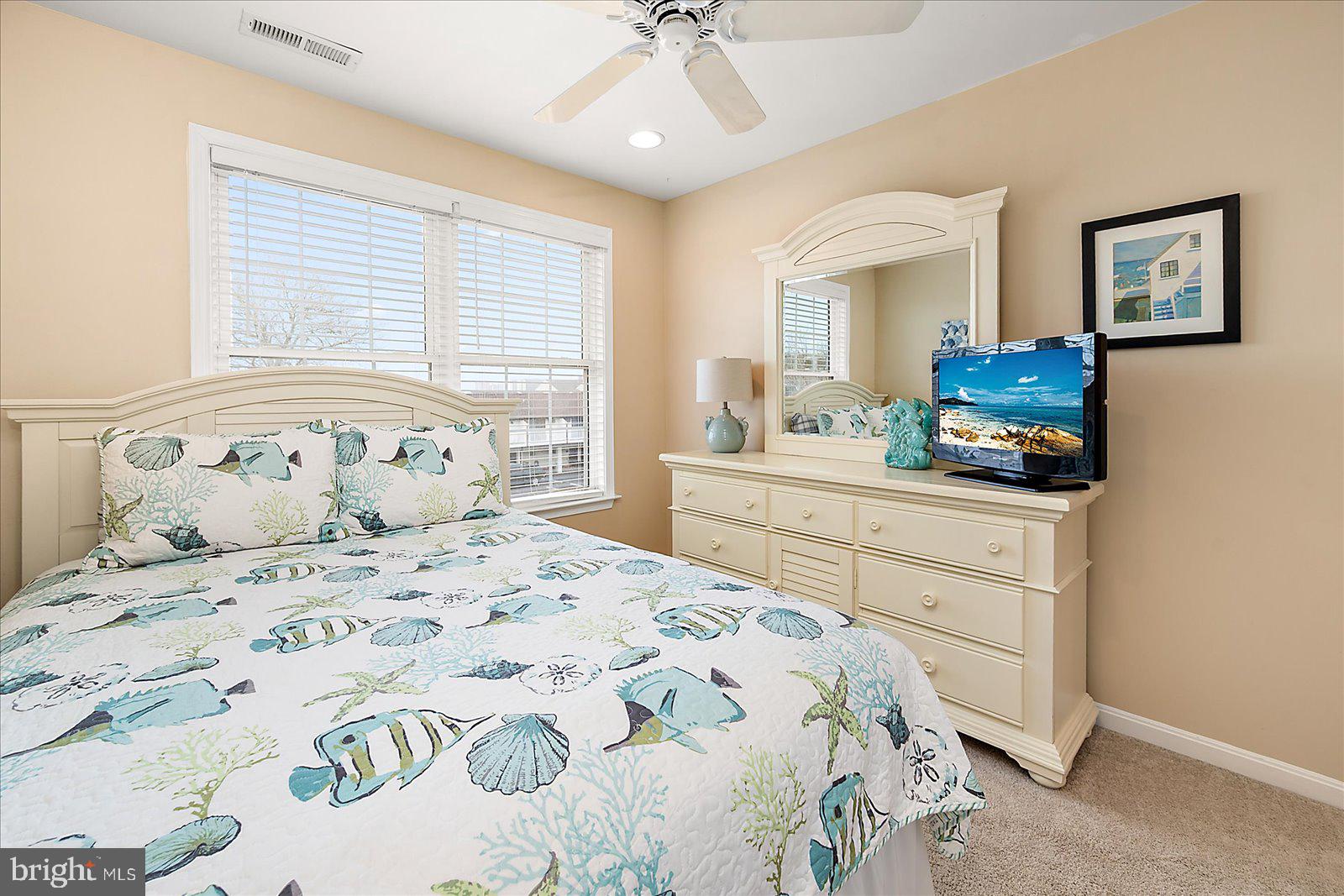 617 Salt Spray Road, Unit D Ocean City, MD 21842 - Photo 31 of 69 a bedroom with a bed and a chandelier