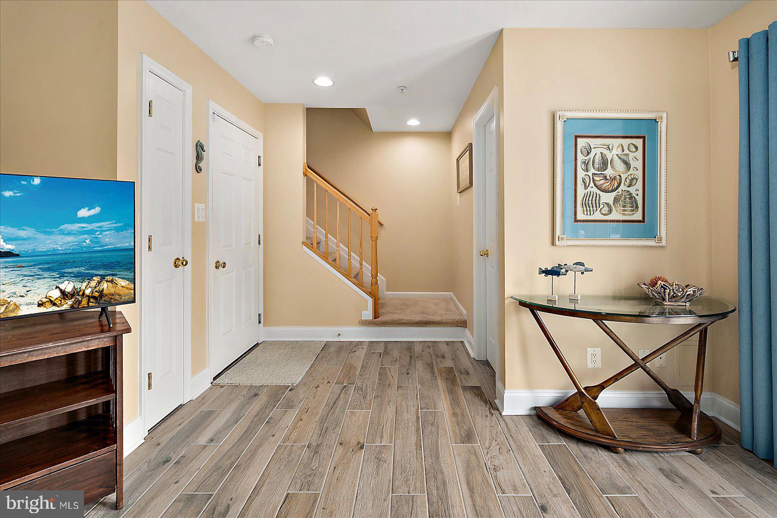 617 Salt Spray Road, Unit D Ocean City, MD 21842 - Photo 34 of 69 a view of a hallway with wooden floor and staircase