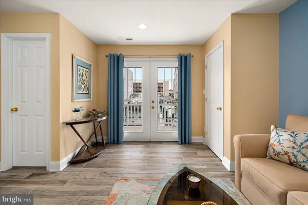 a view of a roof deck with table and chairs a barbeque with wooden floor and fence