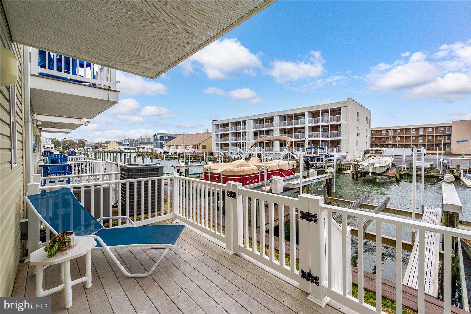 617 Salt Spray Road, Unit D Ocean City, MD 21842 - Photo 40 of 69 a view of a roof deck with table and chairs a barbeque with wooden floor and fence