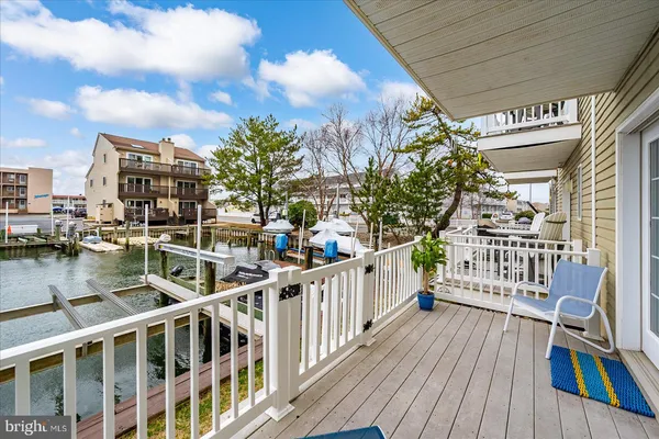 a balcony view with couches and a fireplace with wooden floor