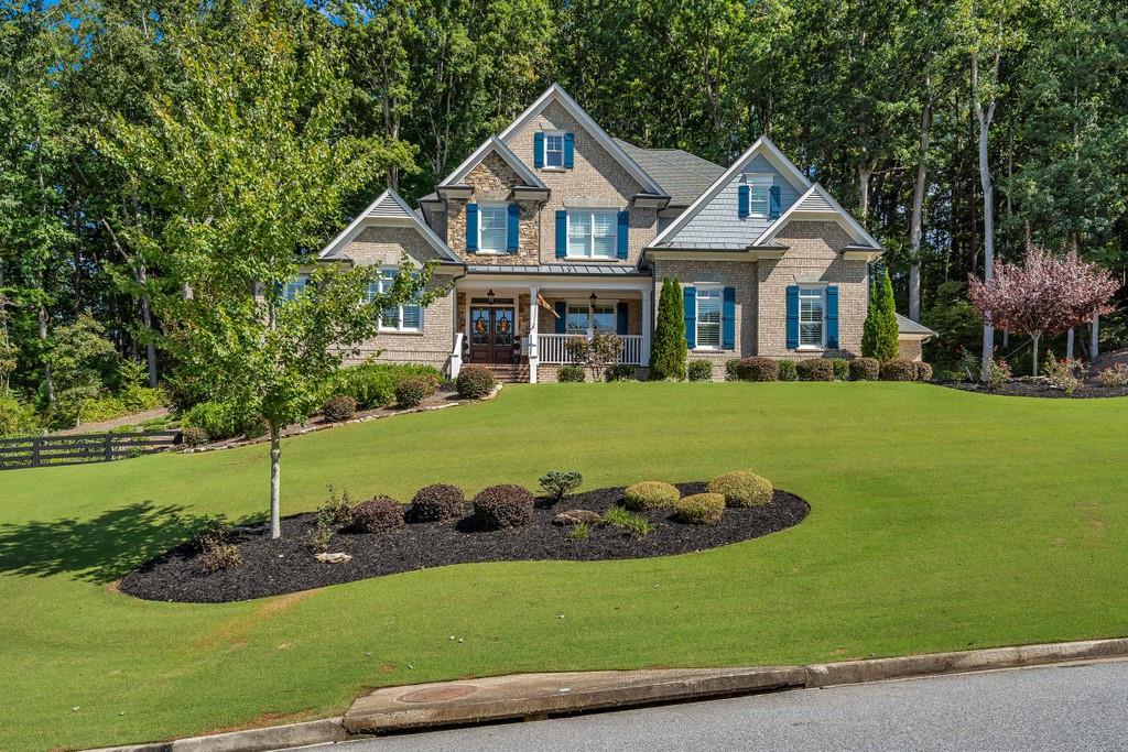 a front view of a house with a garden and trees