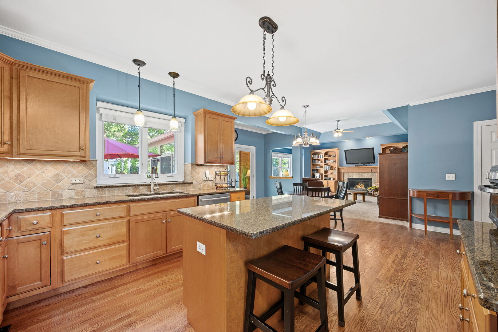 2816 Cordgrass Road Naperville, IL 60564 - Photo 9 of 49 a kitchen with granite countertop a stove a sink a dining table and chairs with wooden floor