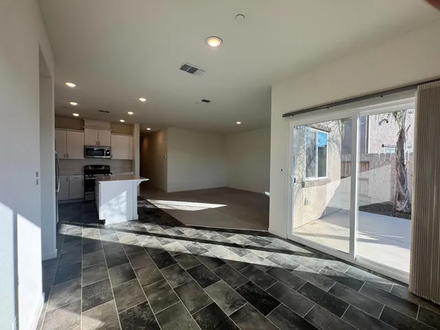 a kitchen with a refrigerator and wooden floor
