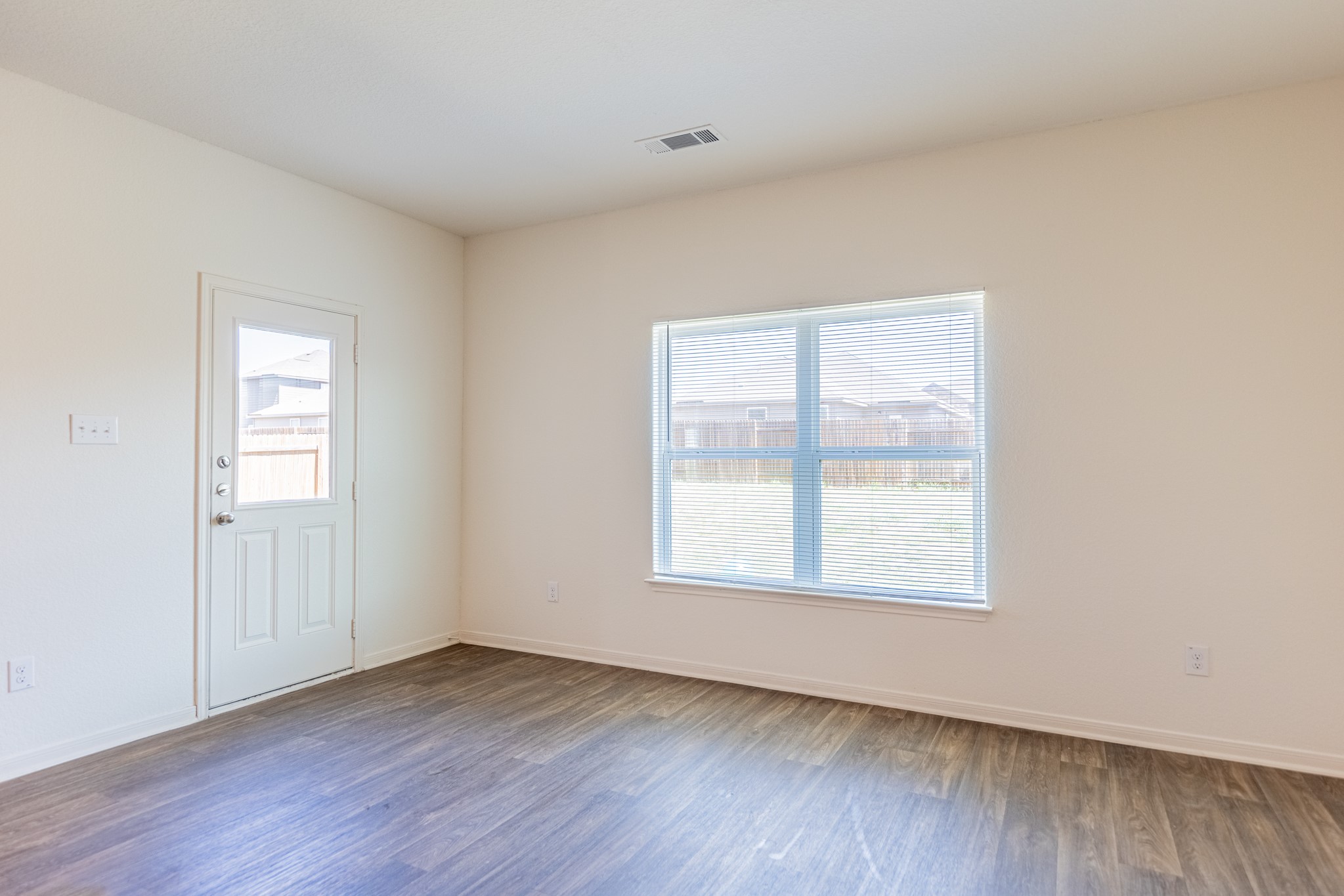 18628 Quiet Range Drive Elgin, TX 78621 - Photo 12 of 32 an empty room with wooden floor and windows