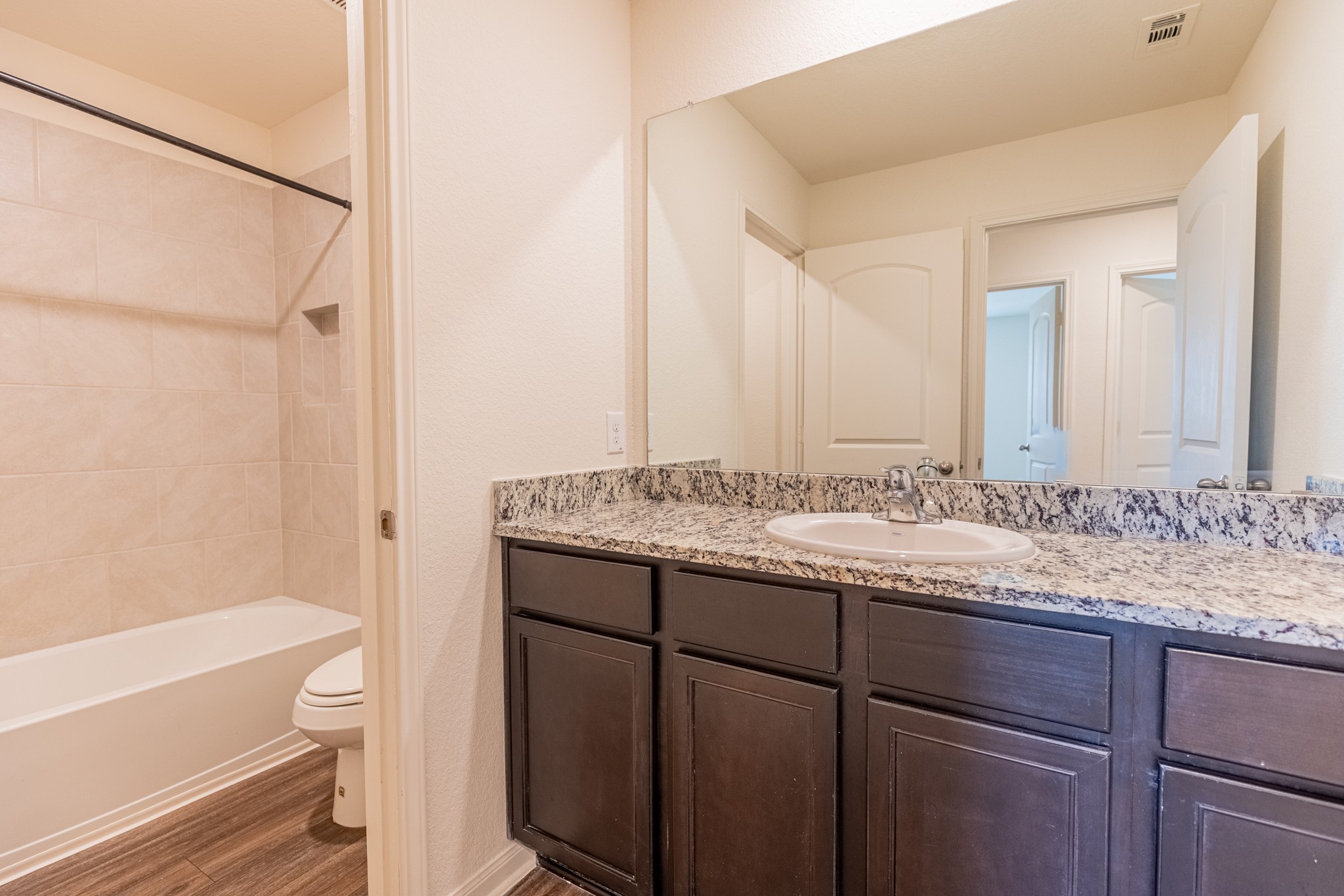 18628 Quiet Range Drive Elgin, TX 78621 - Photo 19 of 32 a bathroom with a granite countertop sink toilet and shower