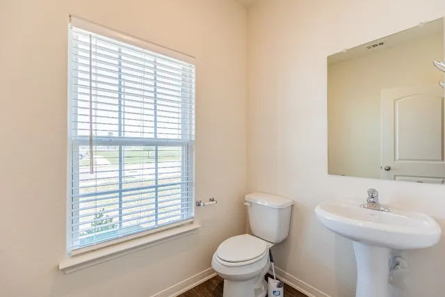 a bathroom with a sink a toilet and a window