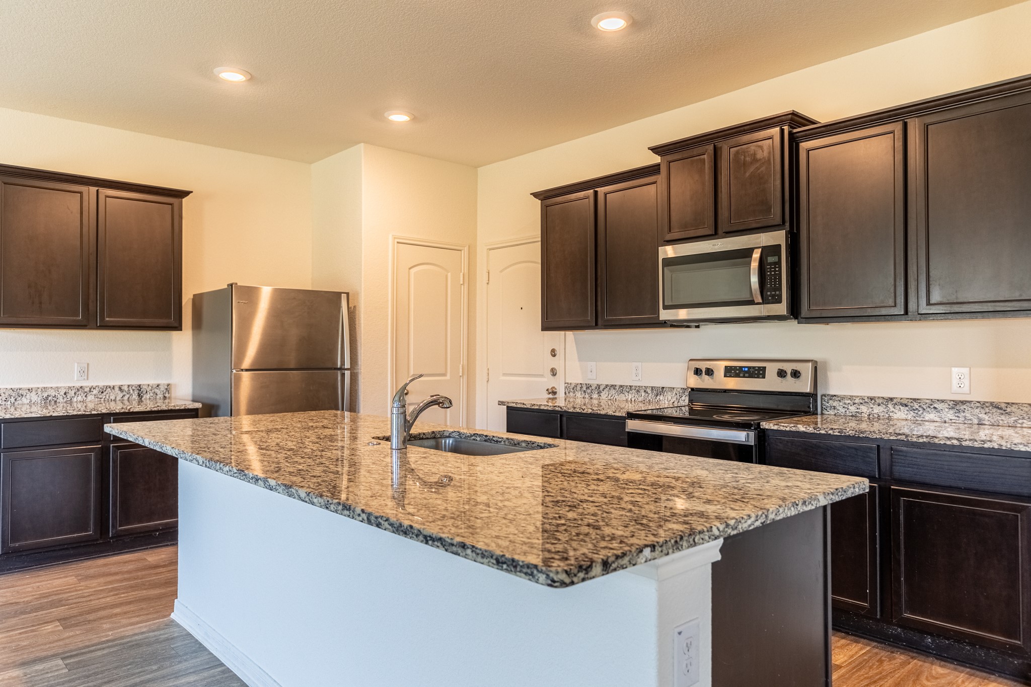 18628 Quiet Range Drive Elgin, TX 78621 - Photo 8 of 32 a kitchen with granite countertop stainless steel appliances a sink stove top oven and granite counter tops