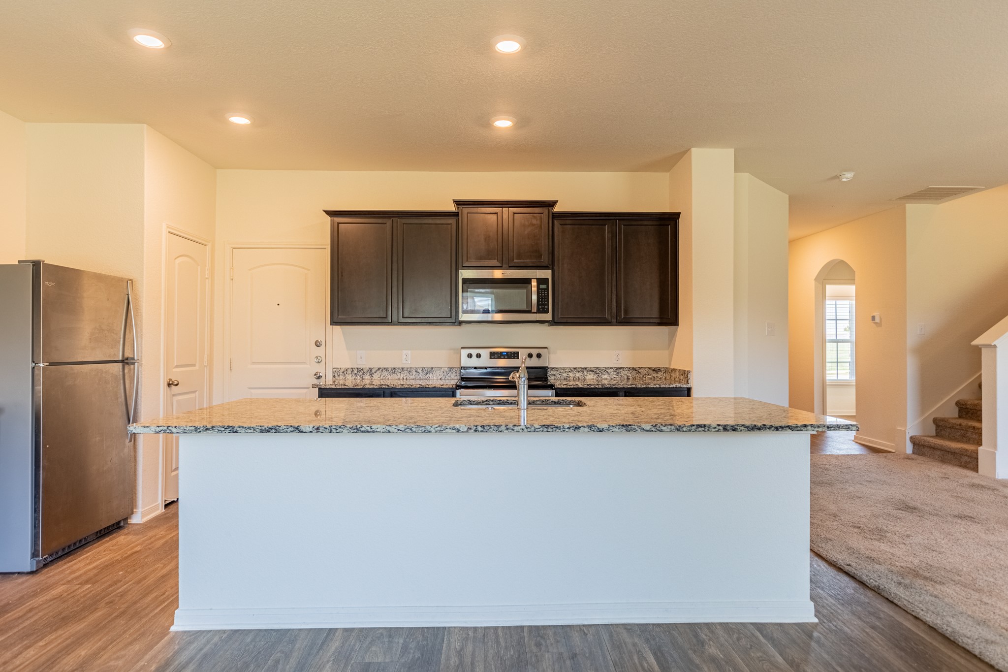 18628 Quiet Range Drive Elgin, TX 78621 - Photo 9 of 32 a large kitchen with granite countertop a sink and a refrigerator