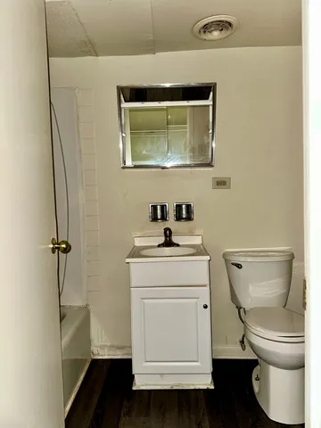 a bathroom with a toilet a sink and mirror