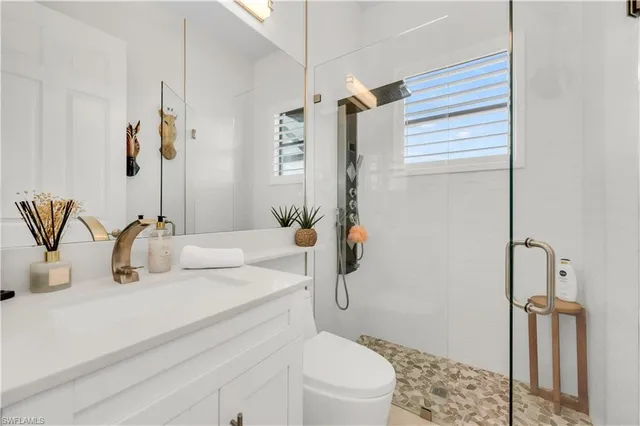 a bathroom with a sink a toilet and shower