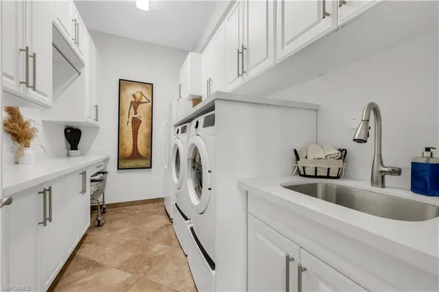 a utility room with cabinets washer and dryer