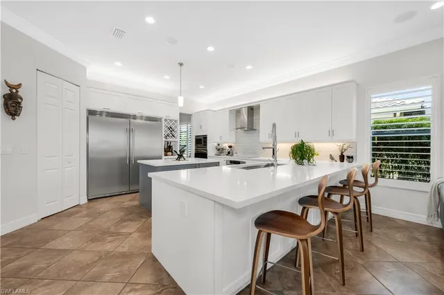 a kitchen with refrigerator and chairs
