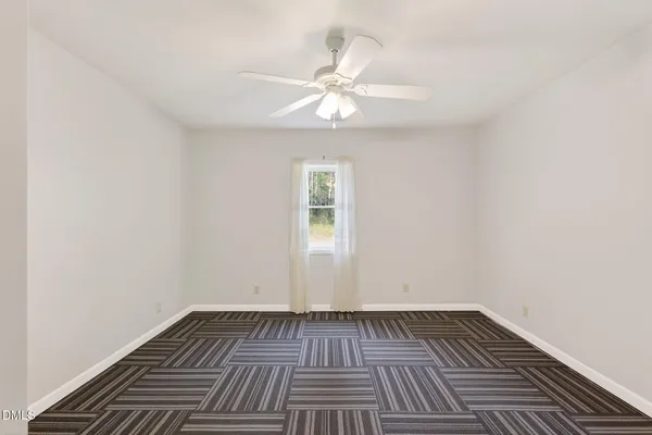 a view of a livingroom with a ceiling fan and window