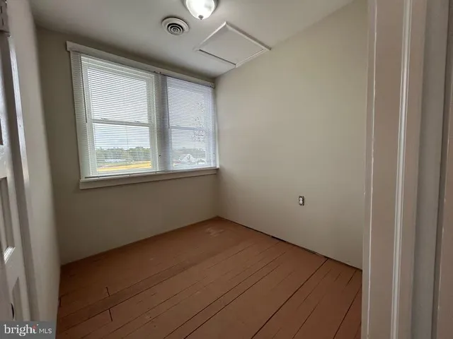 an empty room with a window and a ceiling fan