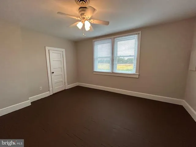a view of cabinets stainless steel appliances wooden floor and a window