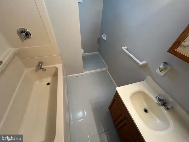 a house that is sitting in the grass with large trees