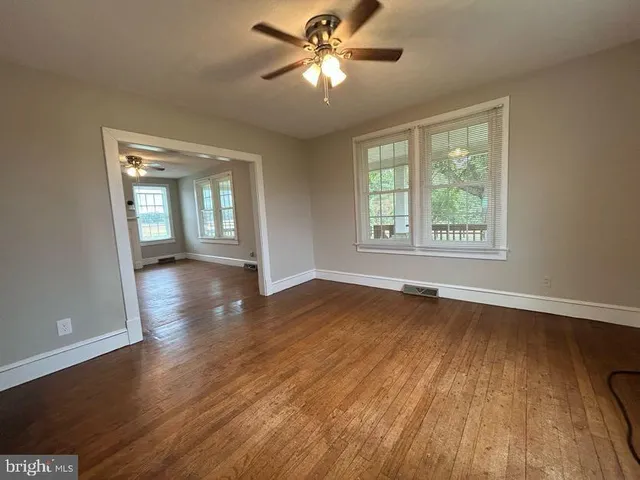 an empty room with wooden floor and window