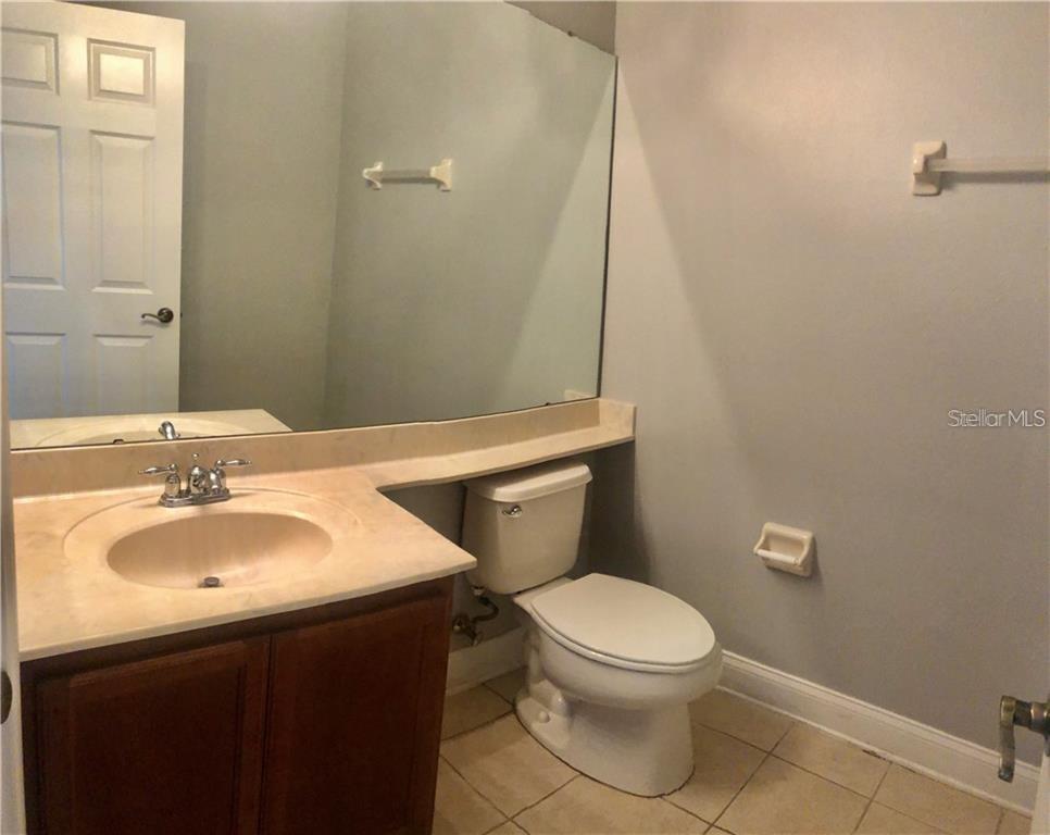 6930 Piazza Street Orlando, FL 32819 - Photo 11 of 25 a bathroom with a sink a toilet and mirror