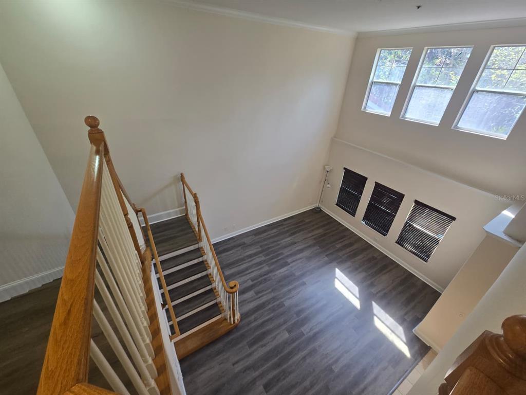 6930 Piazza Street Orlando, FL 32819 - Photo 14 of 25 a view of an empty room with wooden floor and a window