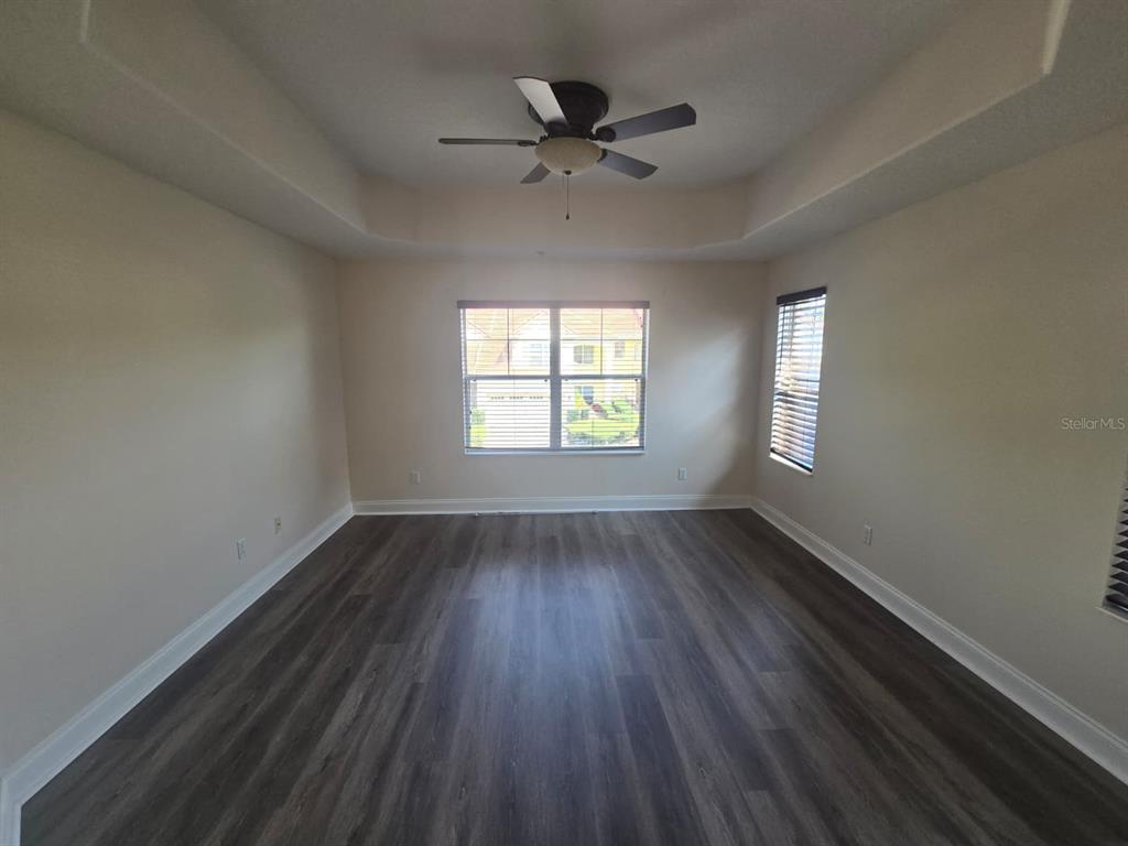6930 Piazza Street Orlando, FL 32819 - Photo 16 of 25 a view of an empty room with wooden floor and a window