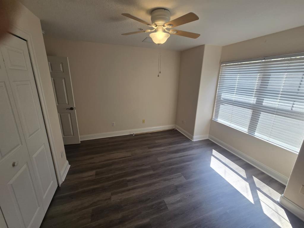 6930 Piazza Street Orlando, FL 32819 - Photo 21 of 25 a view of an empty room with wooden floor and a window