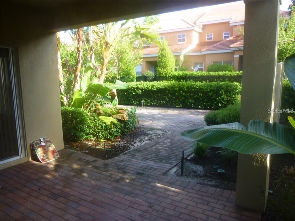 6930 Piazza Street Orlando, FL 32819 - Photo 4 of 25 a view of a garden with a chair and a potted plant