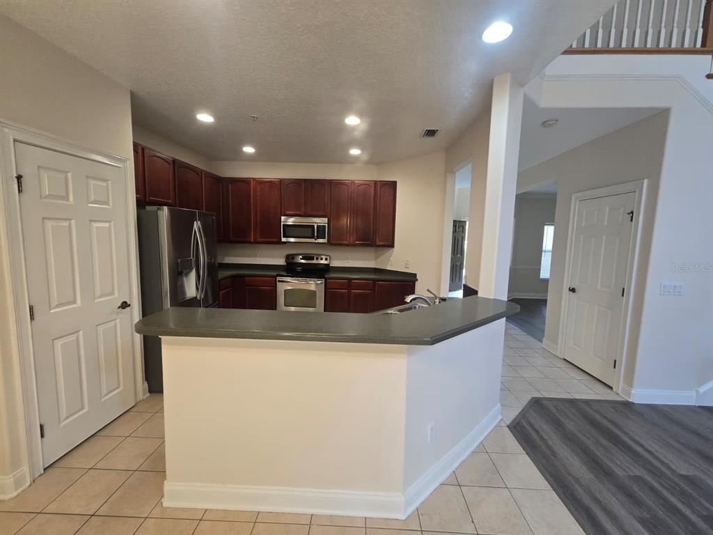 6930 Piazza Street Orlando, FL 32819 - Photo 9 of 25 a kitchen with stainless steel appliances granite countertop a sink and a refrigerator
