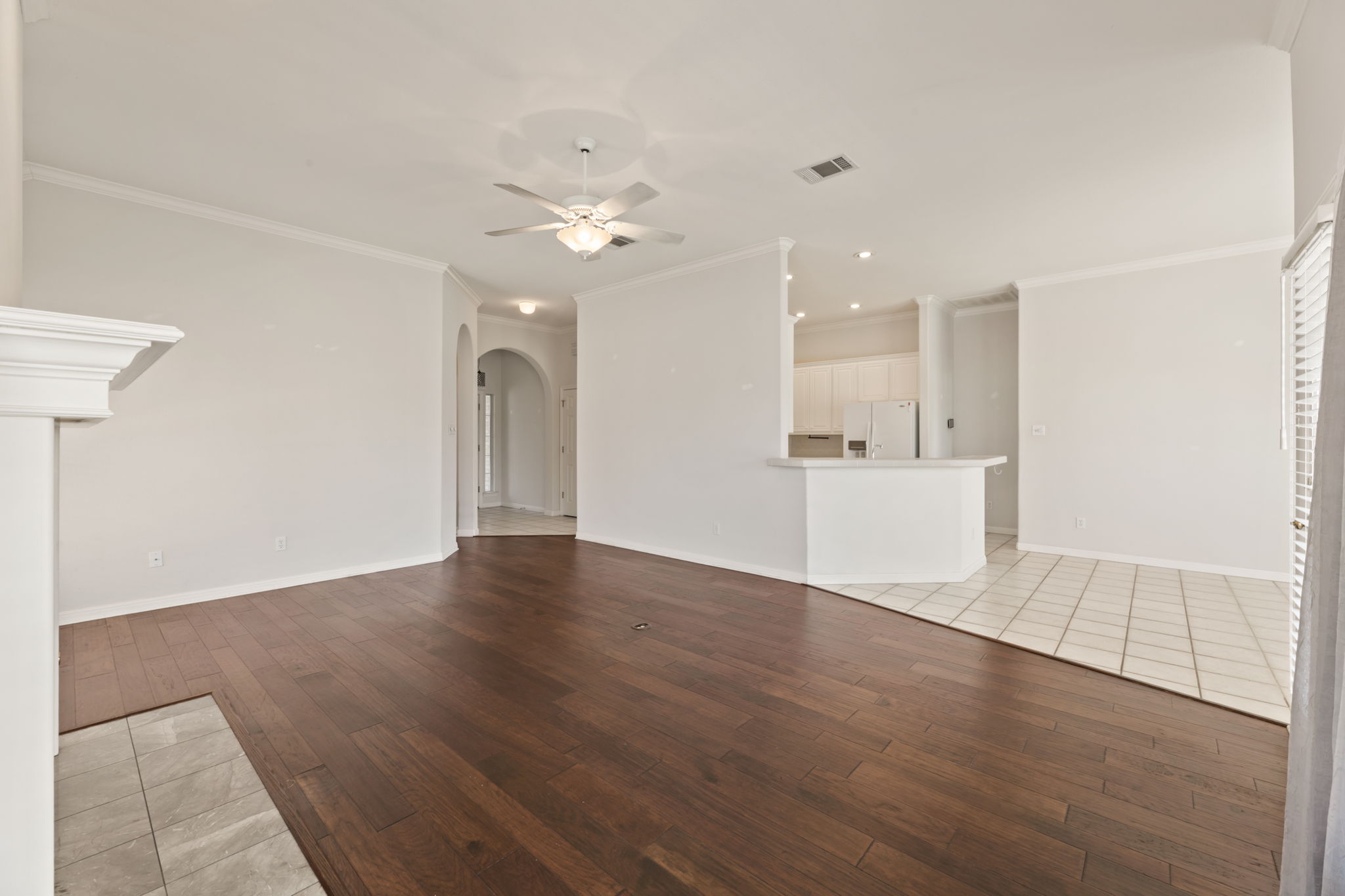 109 Riverview Drive Georgetown, TX 78628 - Photo 12 of 35 Unfurnished living room with light wood-style floors, ceiling fan, arched walkways, and ornamental molding