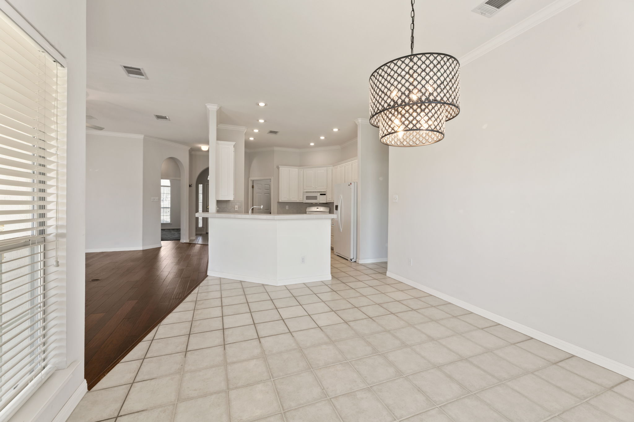 109 Riverview Drive Georgetown, TX 78628 - Photo 34 of 35 Kitchen featuring crown molding, arched walkways, open floor plan, white appliances, and white cabinets