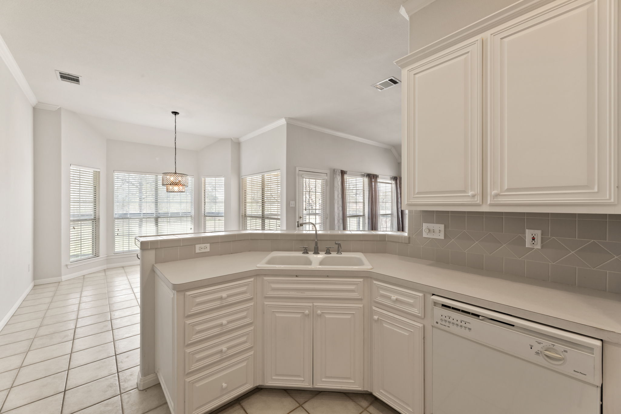 109 Riverview Drive Georgetown, TX 78628 - Photo 14 of 35 Kitchen featuring dishwasher, ornamental molding, a peninsula, light countertops, and backsplash